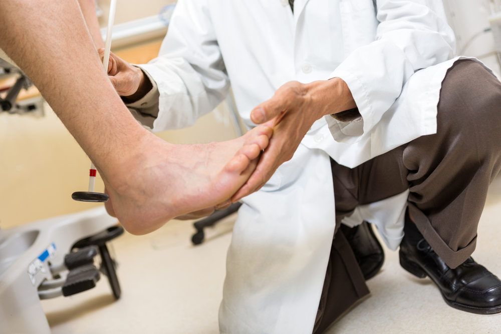 A doctor examining a sore foot to determine if orthotics or other treatments might help alleviate discomfort and restore mobility